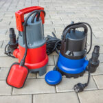 Two,Household,Submersible,Pump,With,Plastic,Housings,On,Stone,Floor